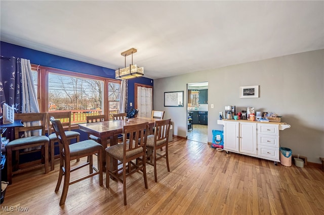 dining room featuring baseboards and light wood-style flooring