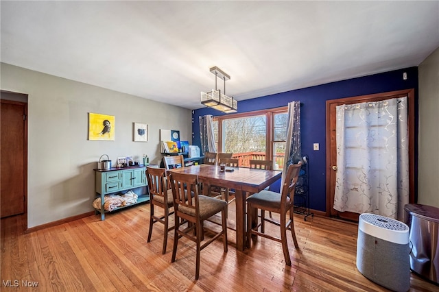 dining space featuring baseboards and light wood-style flooring