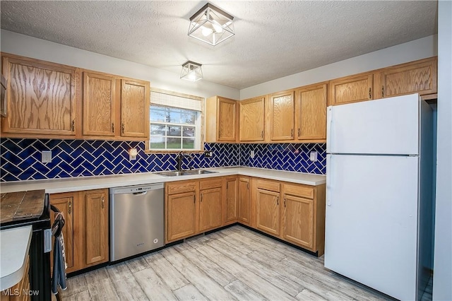 kitchen featuring black / electric stove, tasteful backsplash, dishwasher, a sink, and freestanding refrigerator