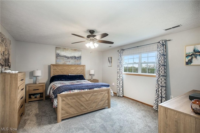 bedroom featuring ceiling fan, carpet floors, a textured ceiling, baseboards, and visible vents
