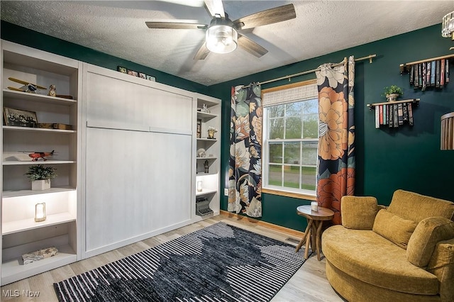 interior space with visible vents, a ceiling fan, a textured ceiling, and wood finished floors