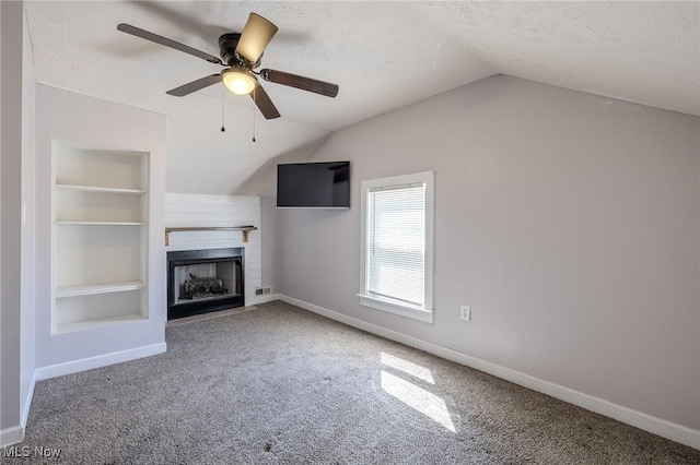 unfurnished living room with a textured ceiling, vaulted ceiling, and built in shelves