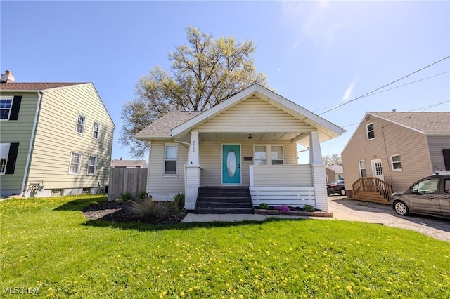 bungalow-style house with covered porch and a front yard