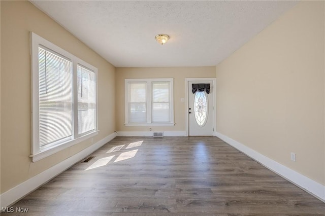 entrance foyer with baseboards, visible vents, and wood finished floors