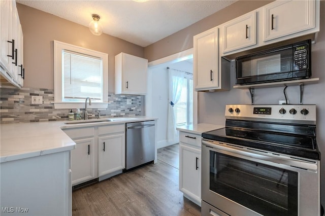 kitchen featuring plenty of natural light, a sink, light wood-type flooring, and stainless steel appliances