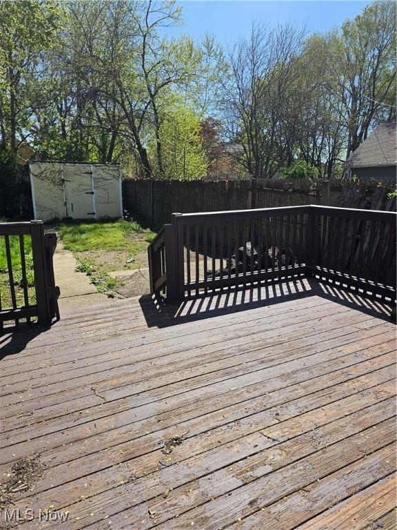 wooden terrace with a fenced backyard