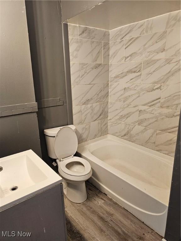 bathroom with vanity, shower / bathing tub combination, toilet, and wood finished floors