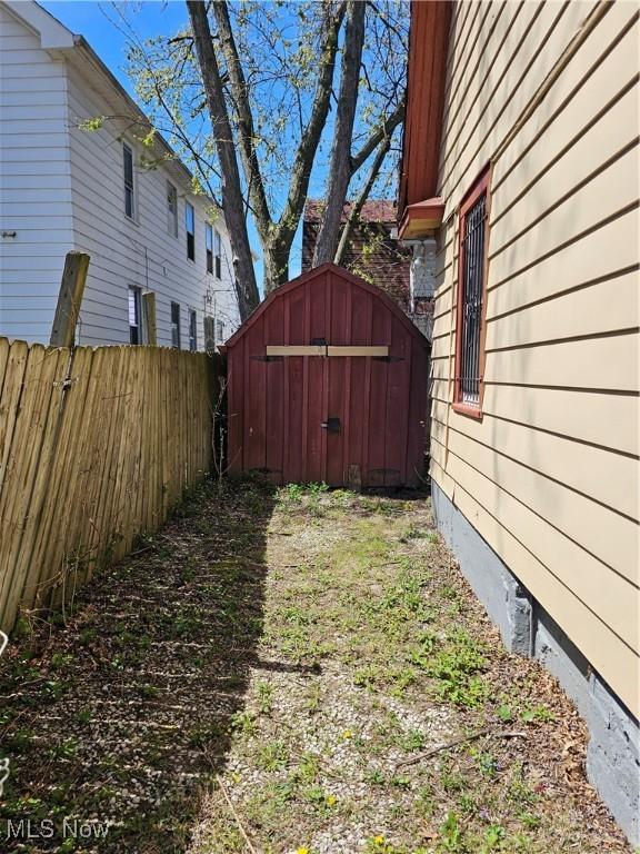 view of yard featuring a shed, an outbuilding, and fence
