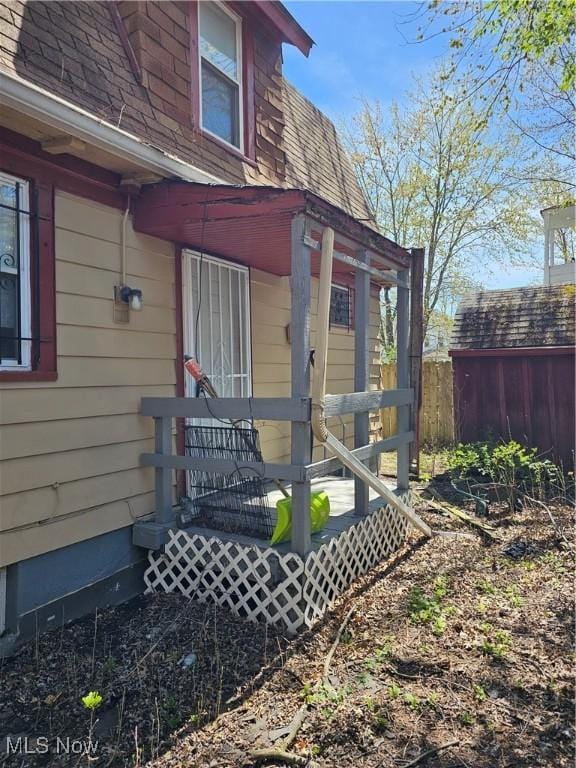 exterior space with roof with shingles and fence