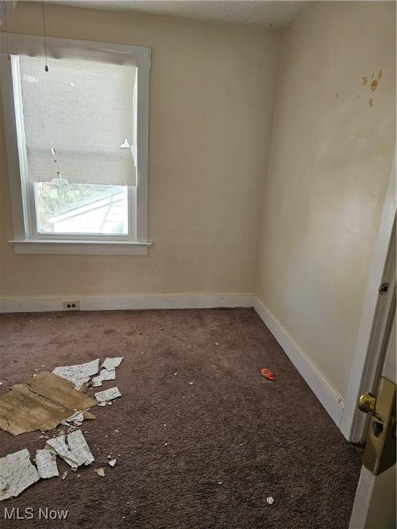 carpeted empty room with baseboards