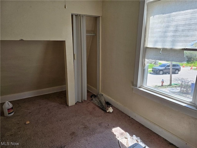 unfurnished bedroom with a closet, baseboards, and carpet flooring