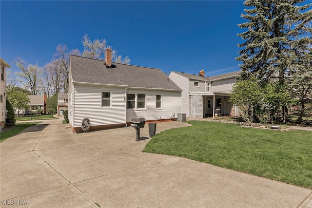 1119 Gordon Rd, Lyndhurst, OH 44124 - back of house featuring central air condition unit, a chimney, a yard, and roof with shingles