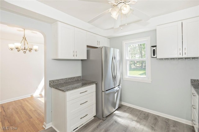 1119 Gordon Rd, Lyndhurst, OH 44124 - kitchen featuring baseboards, light wood-type flooring, white cabinets, arched walkways, and ceiling fan with notable chandelier