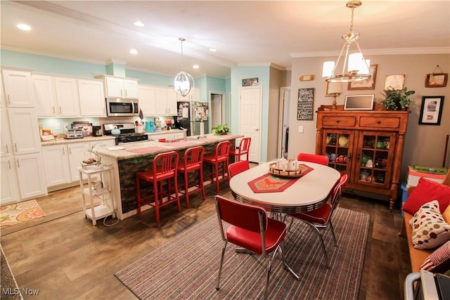 dining space featuring crown molding, recessed lighting, and light wood-style flooring