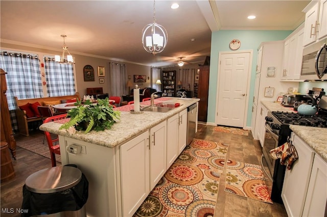 kitchen featuring ceiling fan with notable chandelier, open floor plan, white cabinetry, a sink, and appliances with stainless steel finishes