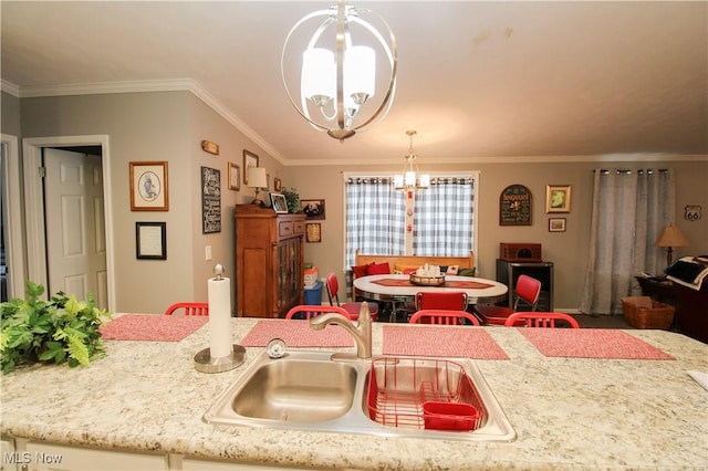 kitchen with a sink, ornamental molding, and a notable chandelier