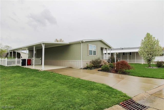 exterior space featuring a lawn, fence, and an attached carport