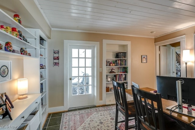 interior space featuring crown molding, dark tile patterned floors, baseboards, and built in features