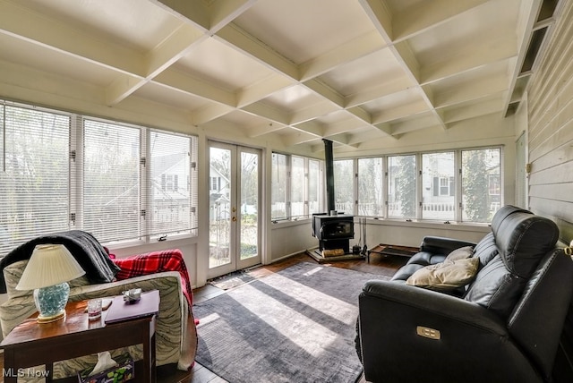 sunroom with a wood stove, wood finished floors, beam ceiling, french doors, and coffered ceiling