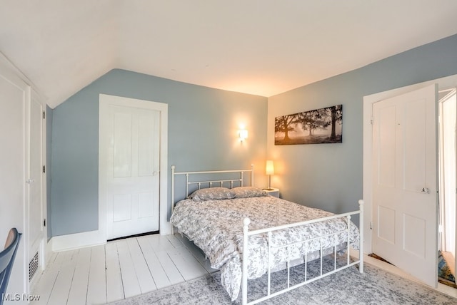bedroom featuring vaulted ceiling and wood finished floors