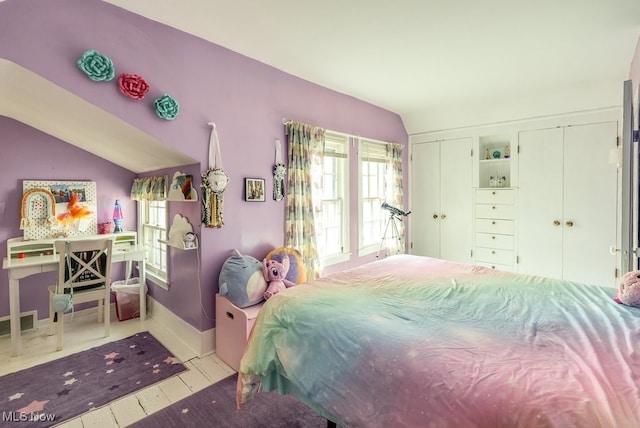 bedroom with baseboards, vaulted ceiling, and visible vents