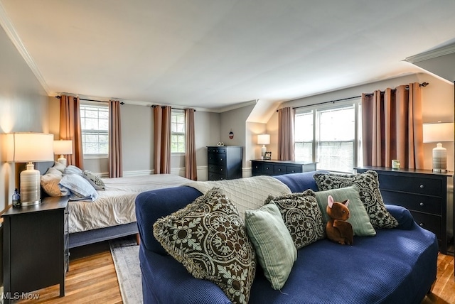 bedroom featuring ornamental molding and wood finished floors