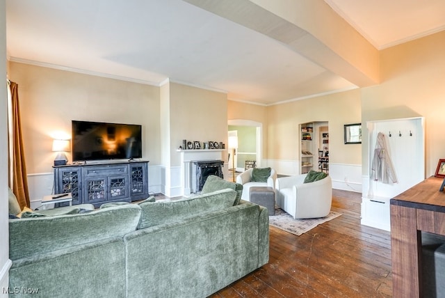 living room featuring crown molding, arched walkways, dark wood finished floors, and a fireplace