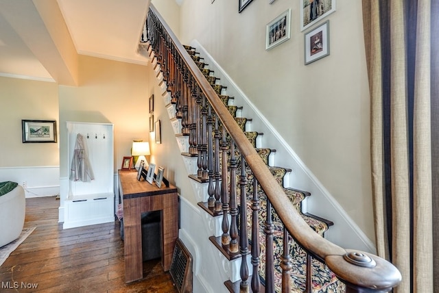 stairway with crown molding and hardwood / wood-style floors