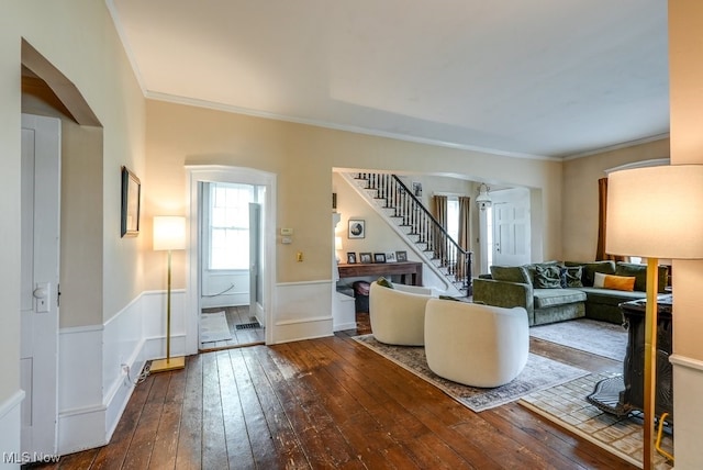 living room featuring ornamental molding, wainscoting, stairway, and hardwood / wood-style flooring