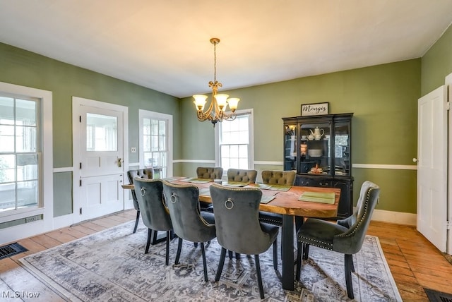 dining area featuring an inviting chandelier, light wood-type flooring, and visible vents