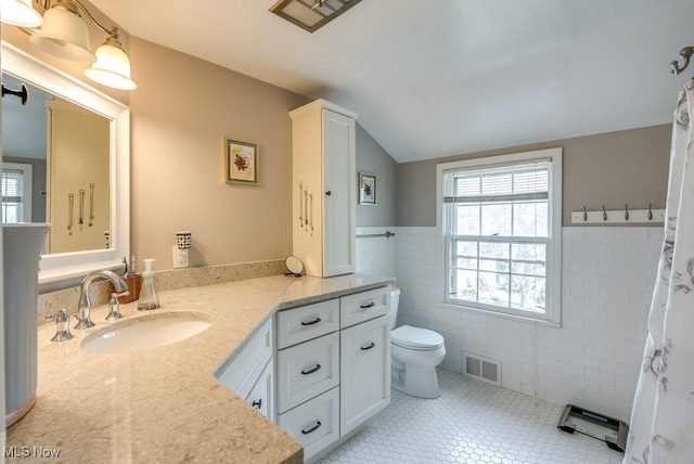 bathroom featuring visible vents, vanity, toilet, tile walls, and tile patterned floors