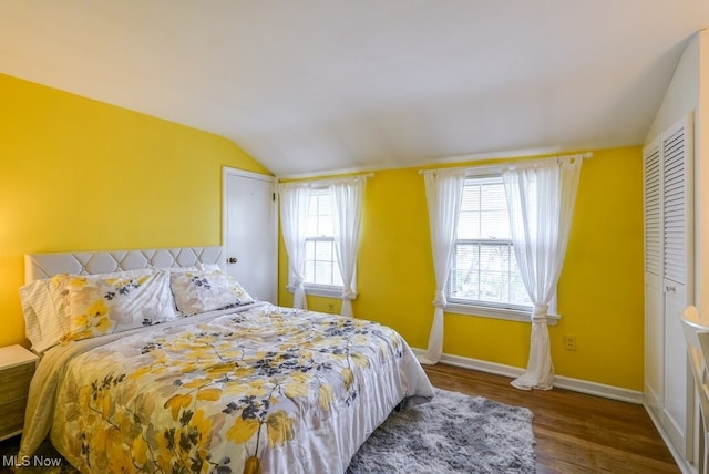 bedroom with baseboards, wood finished floors, and lofted ceiling