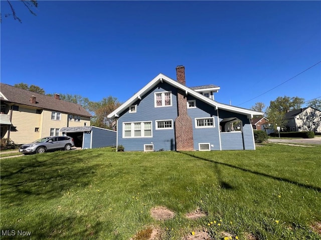 rear view of house with a lawn and a chimney