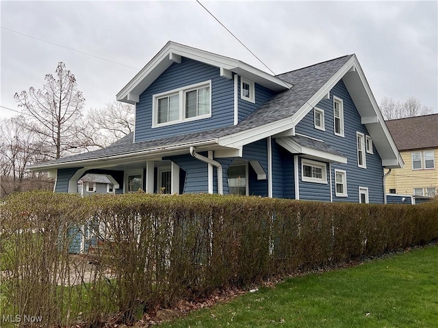 view of side of home featuring roof with shingles