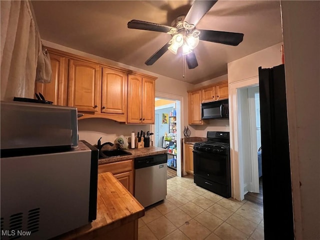kitchen with ceiling fan, a sink, wood counters, light tile patterned floors, and black appliances