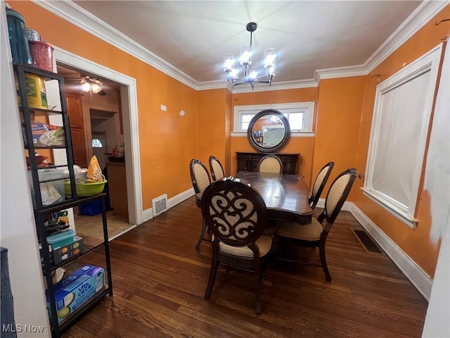 dining room featuring a notable chandelier, baseboards, wood finished floors, visible vents, and ornamental molding