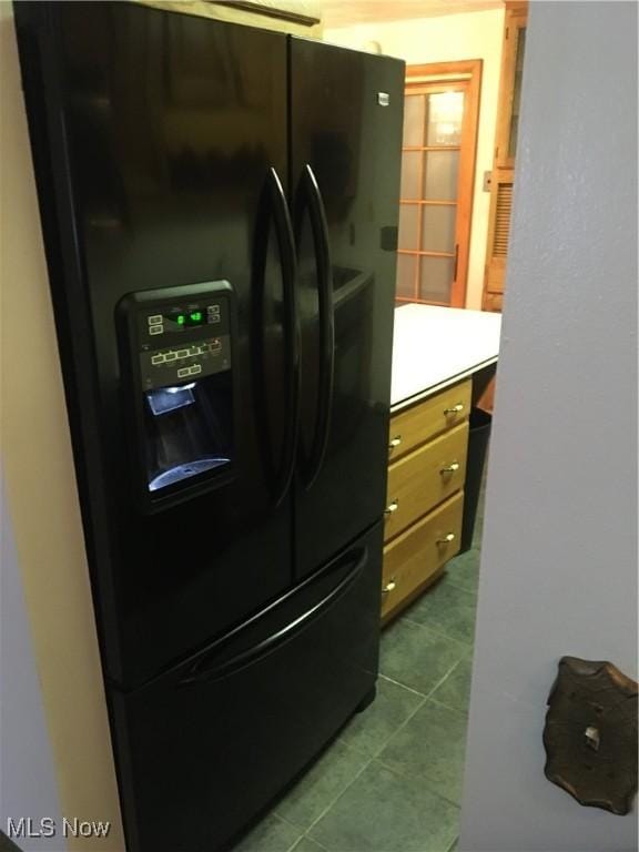 clothes washing area featuring dark tile patterned floors, laundry area, and washer and clothes dryer