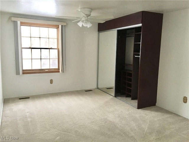 unfurnished bedroom with carpet flooring, ceiling fan, and a closet
