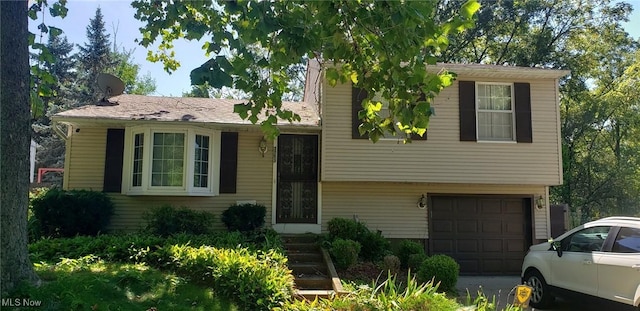 tri-level home featuring an attached garage and driveway