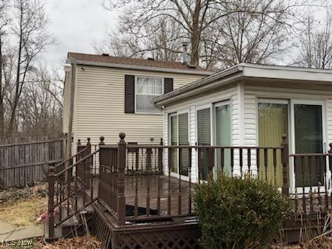 back of house featuring a deck and fence
