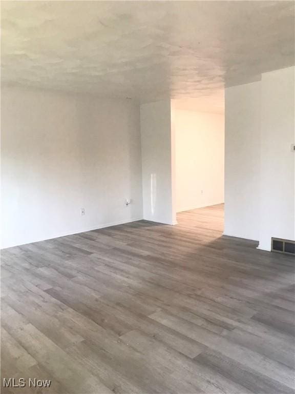 unfurnished room featuring wood finished floors and visible vents