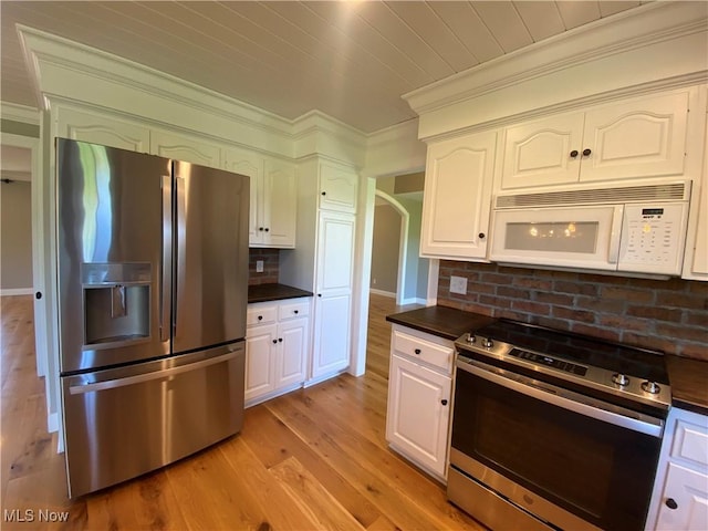 kitchen with crown molding, appliances with stainless steel finishes, and dark countertops