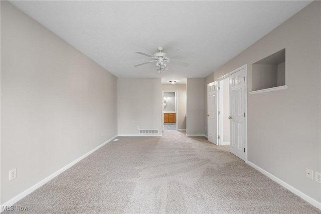 unfurnished room featuring carpet floors, a ceiling fan, baseboards, and visible vents
