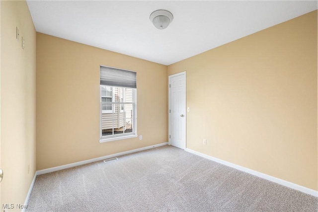 carpeted empty room featuring baseboards and visible vents
