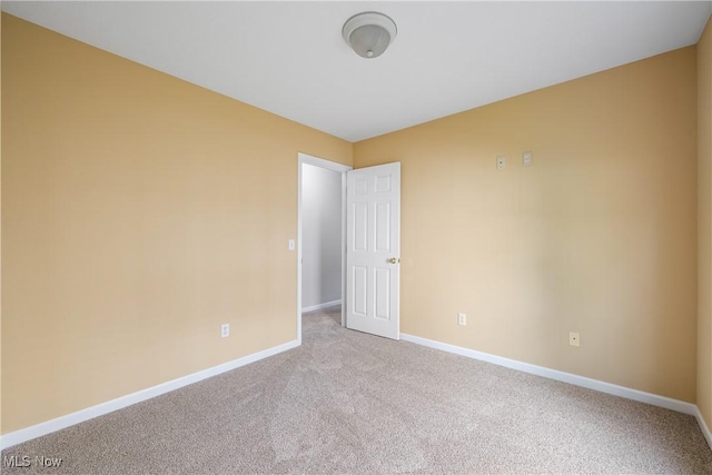 unfurnished room featuring baseboards and carpet