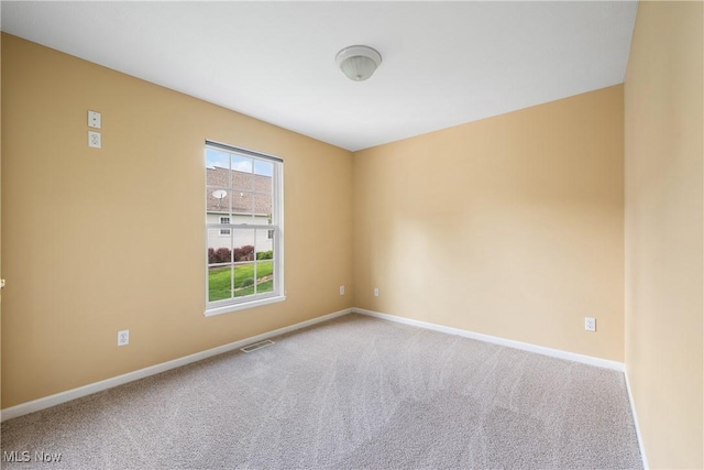 carpeted empty room with baseboards and visible vents
