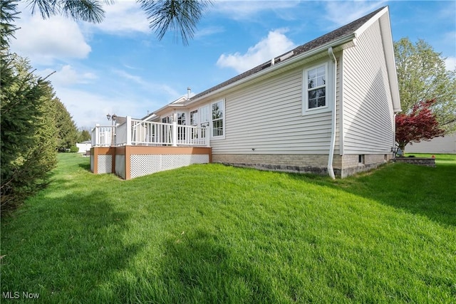 rear view of property featuring a yard and a deck