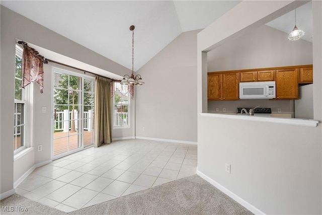 unfurnished dining area with baseboards, light tile patterned floors, lofted ceiling, and a notable chandelier