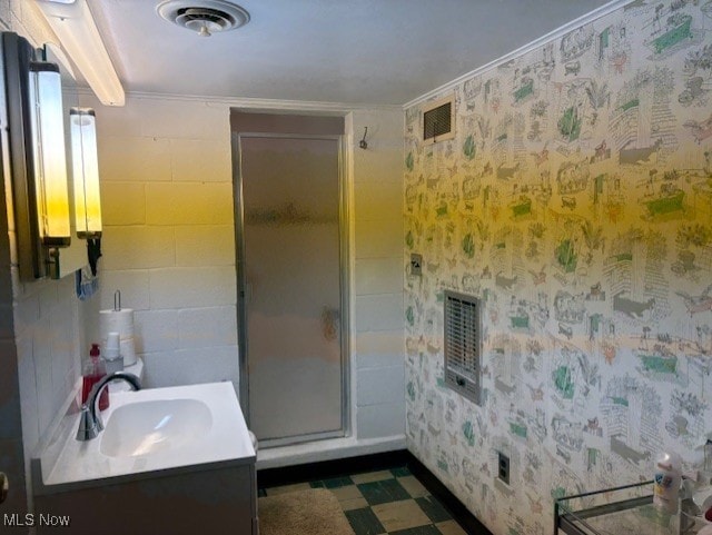 bathroom with tile patterned floors, visible vents, a shower stall, and vanity
