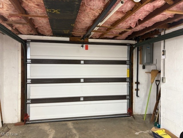 garage featuring electric panel and concrete block wall